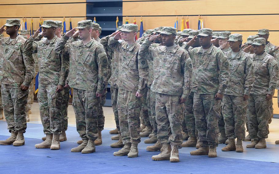 Soldiers of V Corps salute during the playing of the German and American national anthems at the V Corps casing of the colors ceremony at Wiesbaden Army Airfield, Germany, on Thursday. The corps is headed for an Afghanistan deployment, and is leaving Germany for good after more than 60 years.