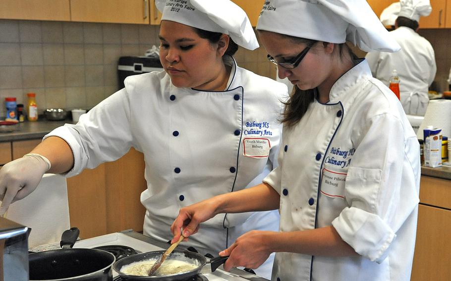 Bitburg&#39;s Yveth Murillo, left, and Cheyenne Pillatzke cook their team&#39;s dishes  at the DODDS-Europe Culinary Arts Faire in Sembach, Germany, Wednesday.