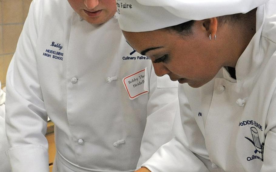 Heidelberg&#39;s Bobby Thomas, left, and Arikka Shepard roll stuffed chicken breasts during the cooking competition at the DODDS-Europe Culinary Arts Faire in Sembach, Germany, Wednesday.