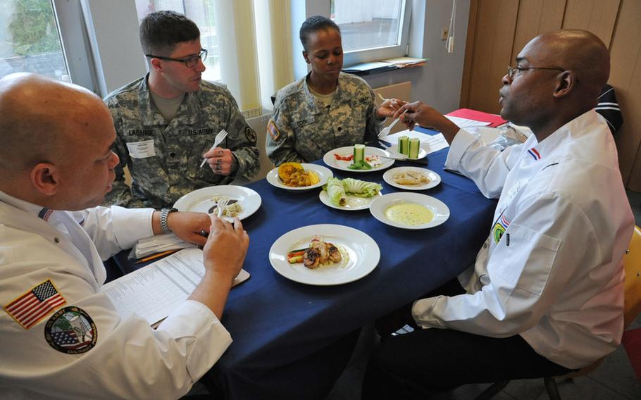 Master Sgt. Major Luckett, Spc. Nicholas LaBarge, Spc. Cleopatra Cook and Staff Sgt. Christopher Rolack, left to right, discuss a dish as they judge the cooking competition at the DODDS-Europe Culinary Arts Faire in Sembach, Germany, Wednesday.