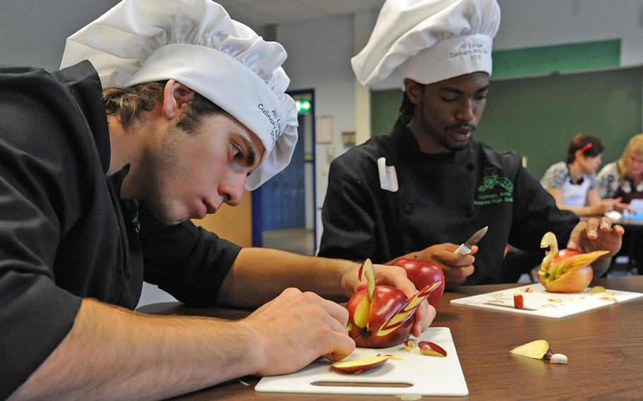 Jorge Campos, left, and Hassan Griffin of Naples, carve apples, one of the competitions at the DODDS-Europe Culinary Arts Faire in Sembach, Germany, Wednesday.