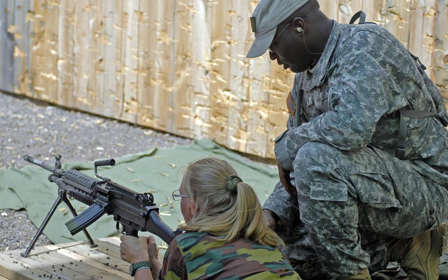 Staff Sgt. Deearrah Wyatt, with the Kaiserslautern-based 361st Civil Affairs Brigade, assists Belgian Sgt. Fabienne Riguel with the M249, or Squad Automatic Weapon, during the 29th annual Monte Kali Pokal shooting competition at the Wackernheim Regional Range complex Friday.