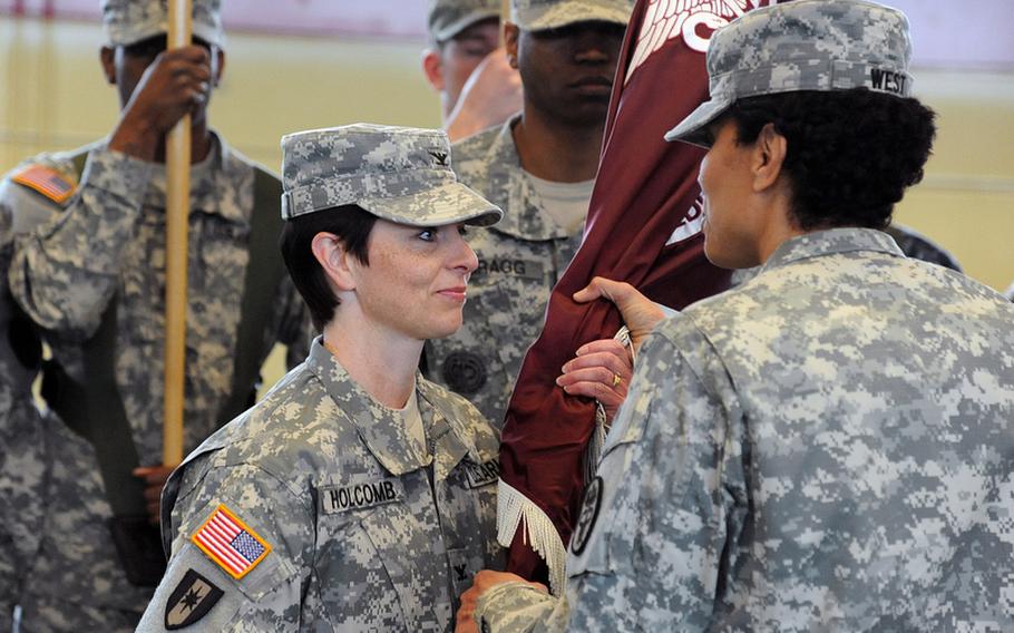 Col. Barbara R. Holcomb, the incoming commander of the Landstuhl Regional Medical Center, left, takes the LRMC colors from Brig. Gen. Nadja Y. West, commander of the Europe Regional Medical Command, at a change of command ceremony in Landstuhl, Germany, May 3. Holcomb took command from Col. Jeffrey B. Clark, who replaced West at ERMC.