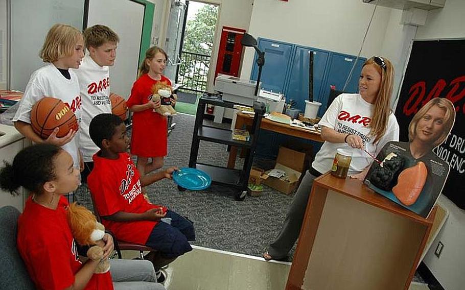 D.A.R.E. officer Ashley Frey shows a group of Shirley Lanham Elementary School students how smoking can damage lungs at Naval Air Facility Atsugi, Japan, on Wednesday.