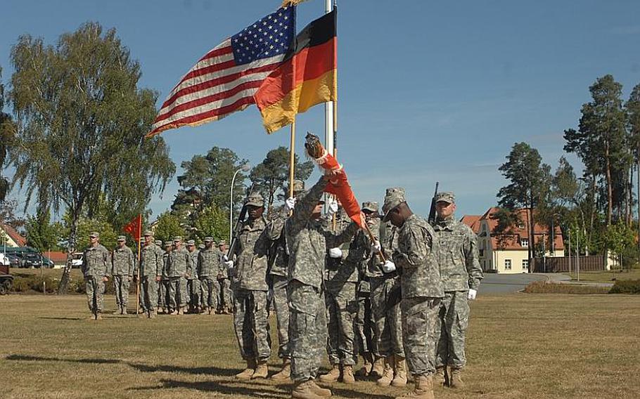 Lt. Col. Robert Fago, left, and Command Sgt. Maj. Charlie Bryant Jr. uncase unit colors for the 44th Expeditionary Signal Battalion in Grafenwöhr, Germany, on Aug. 28, 2012. The battalion, with positions for 480 soldiers, recently moved from the Army post in Schweinfurt, Germany, which is scheduled to close by the fall of 2014.