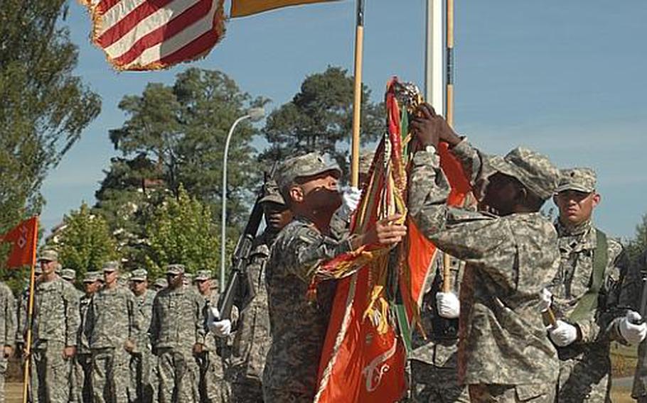 Lt. Col. Robert Fago, left, and Command Sgt. Maj. Charlie Bryant Jr., uncase unit colors for the 44th Expeditionary Signal Battalion in Grafenwöhr, Germany, on Tuesday. The battalion, with positions for 480 soldiers, recently moved from the Army post in Schweinfurt, Germany, which is scheduled to close by the fall of 2014.