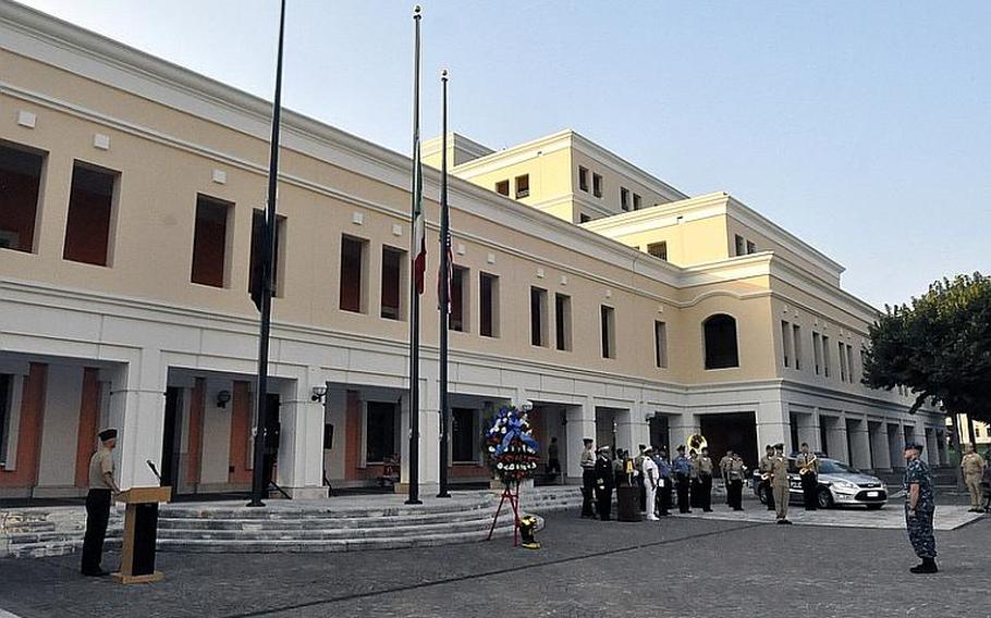 The Italian and American flags are flown at half-mast at the Capodichino base of Naval Support Activity Naples, Italy, during a ceremony honoring the victims of the Sept. 11, 2001, terrorist attacks in the United States. A memorial wreath and a pair of boots representing the victims were centerpieces of the ceremony.