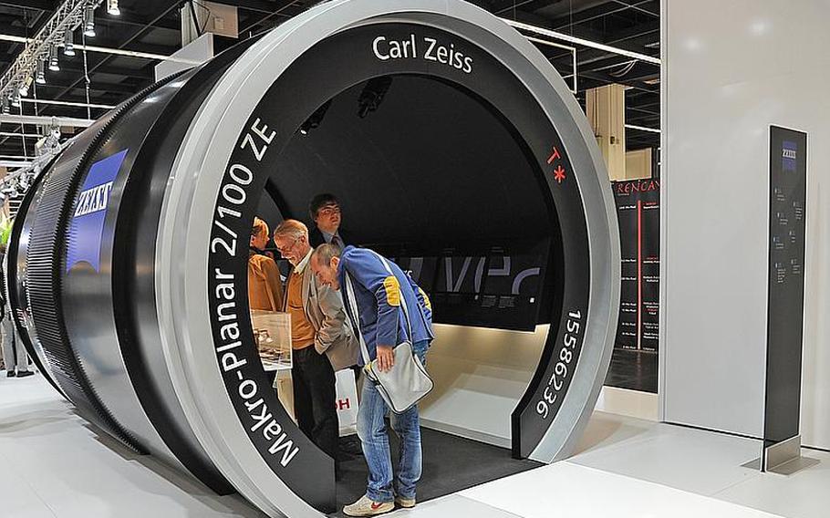 In what looks like it could be "Honey, I shrunk the visitors!", people at Photokina check out a display in an oversized model of a Zeiss lens. Photokina, at the fairgrounds in Cologne, Germany, is billed as the largest imaging trade fair in the world. It is open through Sept. 23, 2012, from 10 a.m. to 6 p.m. Admission is 45 euros, but on Saturday and Sunday family tickets are available for 47 euros for two adults and two children ages 7 to 17.

Michael Abrams/Stars and Stripes