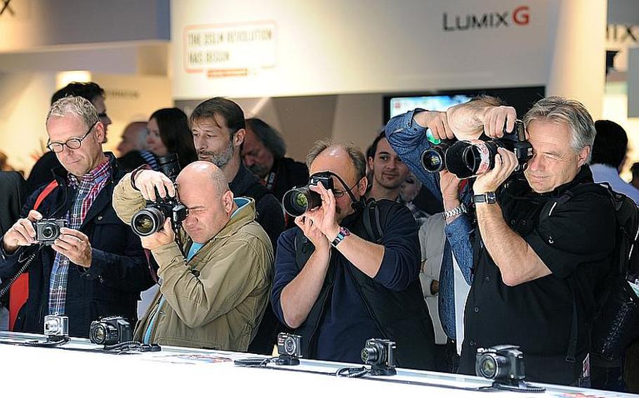 Photographers aim their cameras toward a model at the Panasonic stand during Photokina in Cologne, Germany. Photokina, at the city's fairgrounds, is billed as the largest imaging trade fair in the world. It is open through Sept. 23, 2012, from 10 a.m. to 6 p.m. Admission is 45 euros, but on Saturday and Sunday family tickets are available for 47 euros for two adults and two children ages 7 to 17.