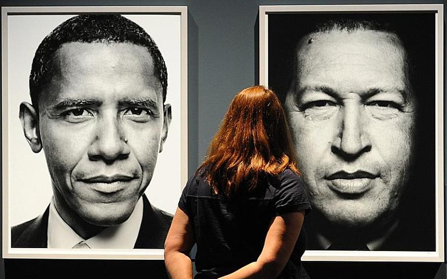 A visitor to the Photokina trade fair in Cologne, Germany, looks at portraits of President Barack Obama, left, and Venezuelan President Hugo Chavez taken by the photographer Platon. Although the trade show focuses on cameras, lenses and other imaging equipment, it also features many photo galleries.