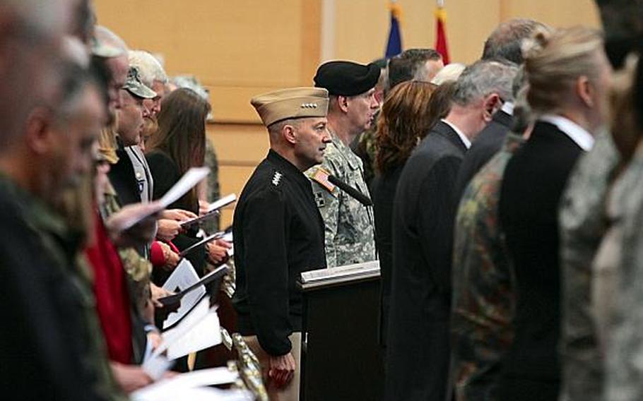 Adm. James Stavridis, supreme allied commander Europe, and Lt. Gen. Donald M. Campbell Jr., commander of U.S. Army Europe, sing along to the Army's official song, ''The Army Goes Rolling Along,'' during Campbell's assumption of command ceremony Wednesday at Wiesbaden, Germany's Clay Kaserne. 