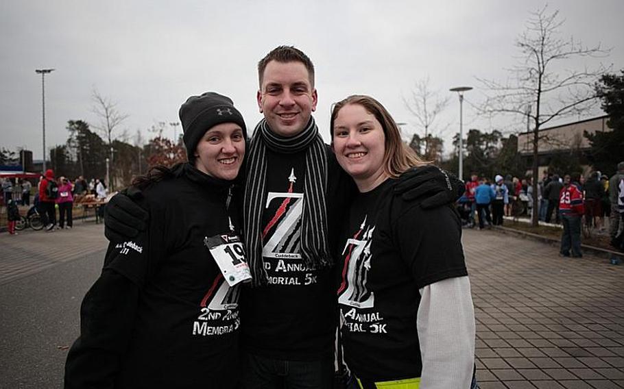 Ashley Rivera, John Tegeler and Monica Luna, all Air Force staff sergeants who were friends and former colleagues of slain Airman 1st Class Zachary Cuddeback, pose in T-shirts worn by organizers of a run in his honor. Cuddeback was one of two airmen killed by a gunman who attacked a group of airmen bound for Afghanistan at Frankfurt Airport on March 2, 2011.