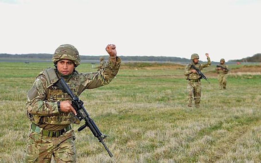 Cpl. Samuela Fifita with the 6th Contingent of the Tonga Defense Services, raises his hand to bring the unit to a stop during military dog familiarization training at RAF Honington on April 15. The 6th Contingent is scheduled to deploy to Afghanistan after completing an eight week course of training with the British military.

Adam L. Mathis/Stars and Stripes