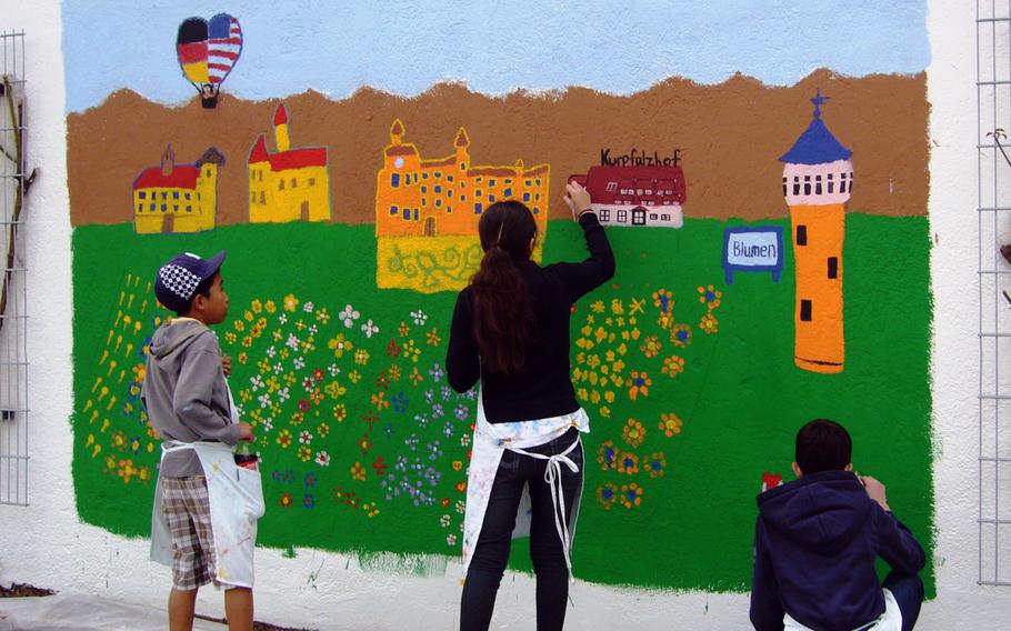 Heidelberg Middle School students, from left to right, Nico Amante, Katrina Tudlong and Kevin Gillespie, work on a mural that the school plans to dedicate to Heidelberg and surrounding communities at a ceremony Friday at 4 p.m. at Eppelheim City Hall.