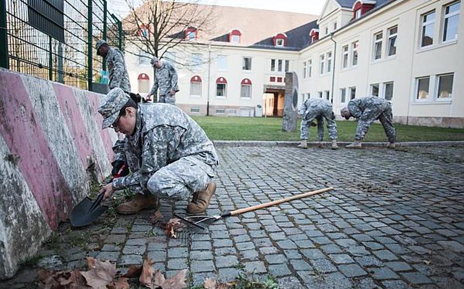 Soldiers with the 266th Financial Management Center in Kaiserslautern, Germany, remove weeds near an entrance to Kleber Kaserne on Thursday, April 25, 2013. Soldiers around Europe spent the morning cleaning up bases as part of community spring cleanups.