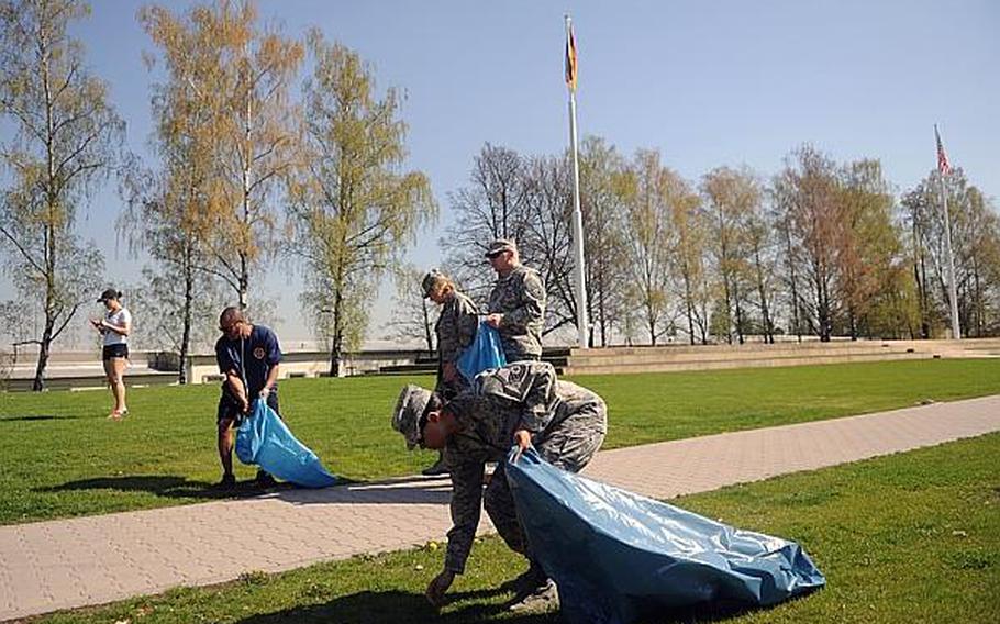 Air Force Master Sgt. Natasha Weaver, foreground, with European Command Public Affairs, and other members of the command participate in a community cleanup on Patch Barracks, in Stuttgart, Germany, on Thursday, April 25, 2013.
