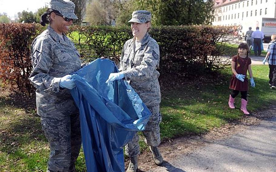 Air Force Master Sgt. Natasha Weaver, left, with European Command Public Affairs, and Tech. Sgt. Liz Rabjahn with EUCOM's Interagency Partnering Directorate, pick up trash on Patch Barracks in Stuttgart, Germany, on Thursday, April 25, 2013.