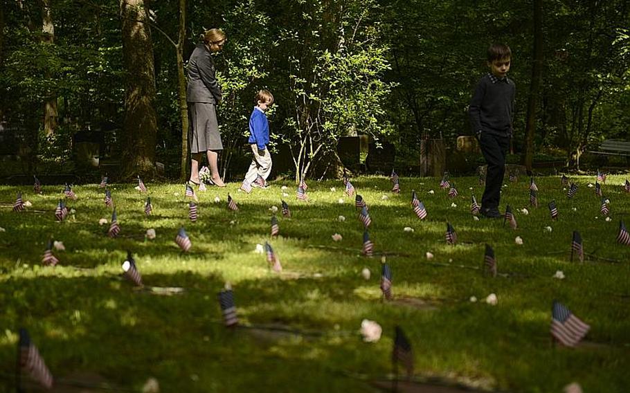 Katie Pelletier and her sons, Jude, middle, and Luke look at the head stones of American children after the annual Kindergraves memorial service May 18, 2013, at the main cemetery in Kaiserslautern, Germany. 

