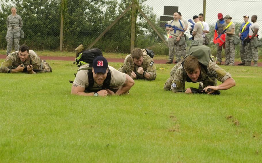 Airmen crawl across a wet field at Heritage Track at RAF Mildenhall, England, on Wednesday, July 3, 2013 during the first event of the Monster Mash. The 10-event course had  both mental and physical tests.