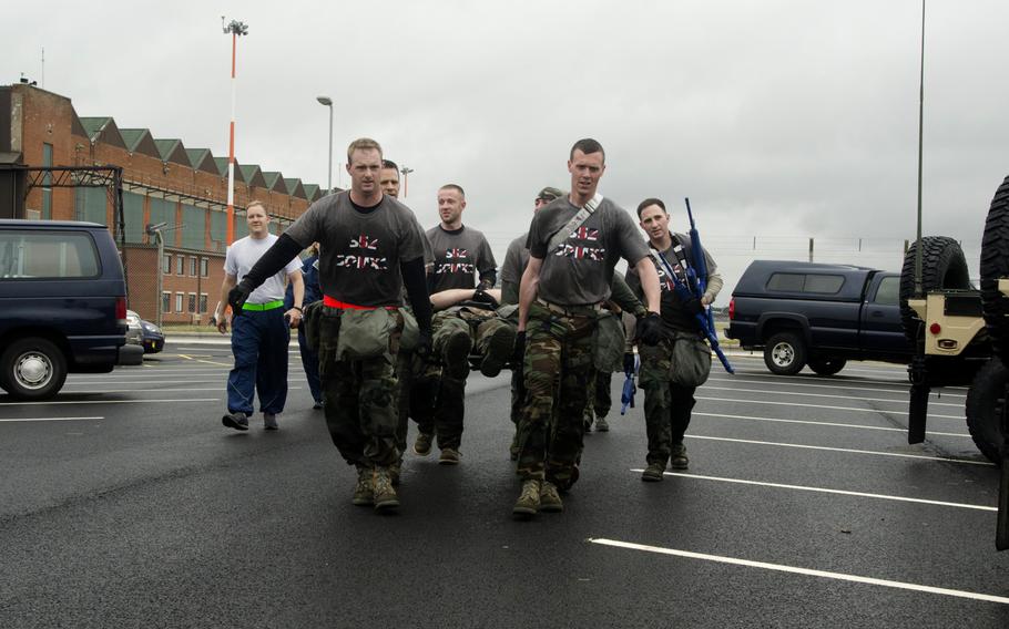 Airmen bear a teammate in a litter on Wednesday, July 3, 2013, during the 352nd Special Operations Group's Monster Mash competition  at RAF Mildenhall, England. When the litter carry ended, one person from the team was called upon to answer questions about medical care before the team was allowed to move on to the next event.
