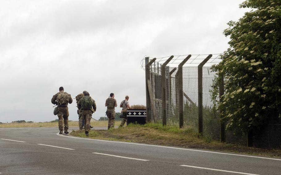 Nearing the end, participants in the 352nd Special Operations Group's Monster Mash carry backpacks down a path on RAF Mildenhall, England, on Wednesday, July 3, 2013, toward one of the last stations in the course.