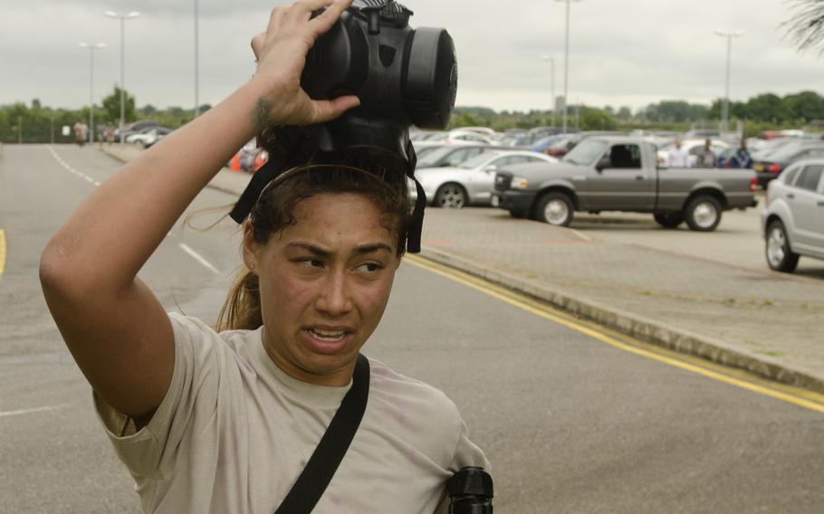 Airman 1st Class Julia Cap takes off her gas mask after completing the gas mask run/sprint portion of the Monster Mash at RAF Mildenhall, England, on Wednesday, July 3, 2013.