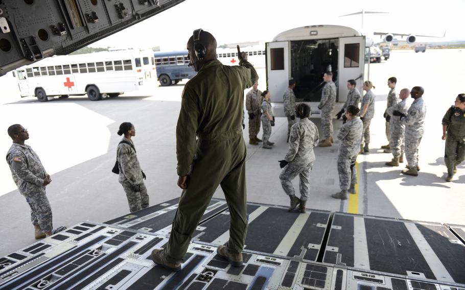 Medical personnel with the Acute Lung Rescue Team and Ramstein Air Base and Landstuhl Regional Medical Center volunteers prepare to transfer a patient on extracorporeal membrane oxygenation treatment from an ambulance bus onto a C-17 Globemaster III on Ramstein Air Base, Germany, for a flight to the San Antonio Military Medical Center, Texas.