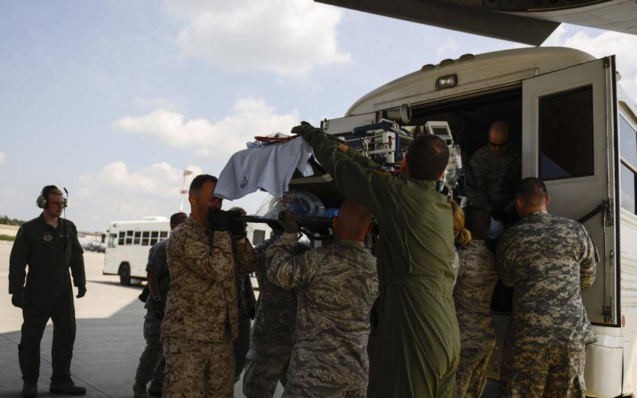 Medical personnel with the Acute Lung Rescue Team along with Ramstein Air Base and Landstuhl Regional Medical Center volunteers prepare to transfer a patient on extracorporeal membrane oxygenation treatment from an ambulance bus onto a C-17 Globemaster III on Ramstein Air Base, Germany, for a flight to the San Antonio Military Medical Center, Texas. This was the first time the military moved an ECMO patient over such a distance.