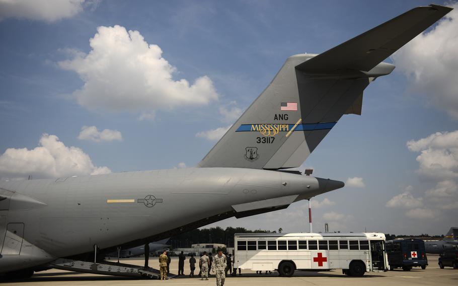 Medical personnel with the Acute Lung Rescue Team and Critical Care Air Transport Team along with Landstuhl Regional Medical Center volunteers prepare to transfer a patient on extracorporeal membrane oxygenation treatment from a ambulance bus onto a C-17 Globemaster III on Ramstein Air Base, Germany. The ALRT on July 10, 2013, aided in the the longest-known move of a patient on extracorporeal membrane oxygenation treatment, flying her from Ramstein, Germany, to San Antonio Military Medical Center, Texas.