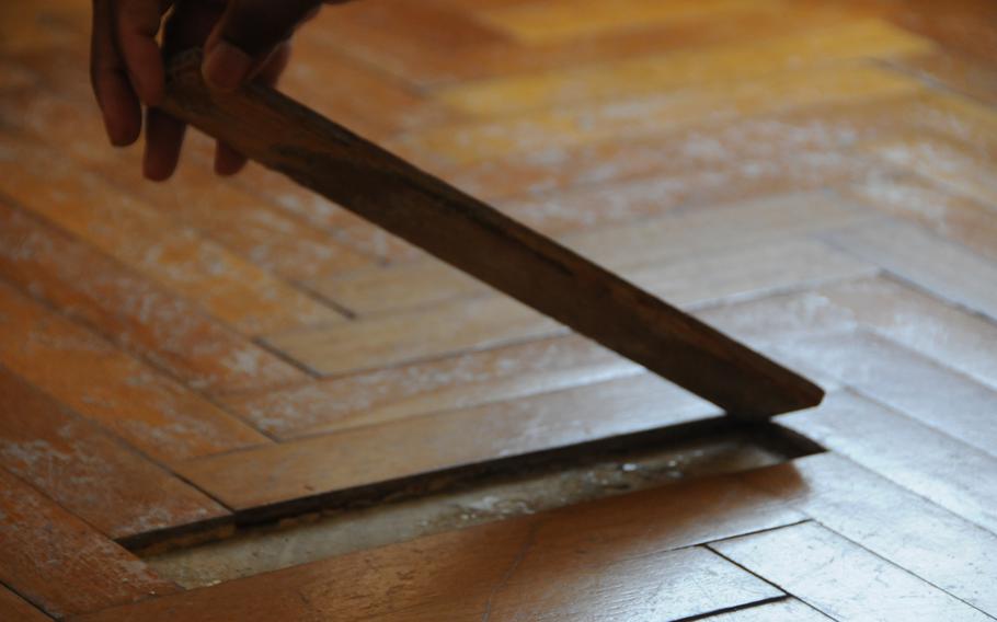 A wooden slat from the flooring Brandy Clingan used as her office damaged by water intrusion.