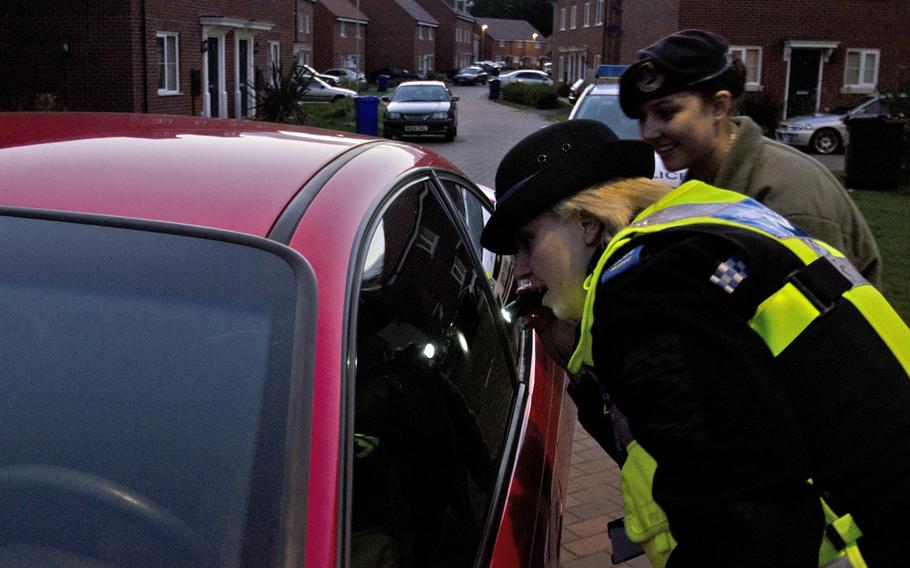 Anne-Marie Powell, Suffolk police community support officer, and Senior Airman Kiirstyn Williams, with the 48th Fighter Wing, inspect a car in Suffolk, England, Wednesday, Sept. 18, 2013. Their inspection was part of a safety patrol to warn people about the dangers of leaving their vehicles unlocked and leaving valuables on display.