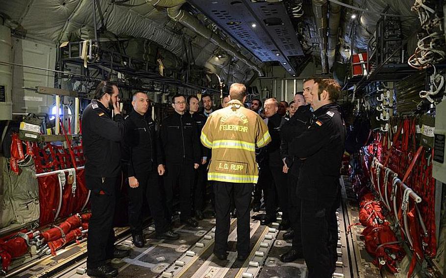 Station Capt. Klaus Rupp, of Kaiserslautern Military Community Fire Department's Fire Station No. 1, briefs German soldiers from the 8th Kompanie, Spezialpionierbatallion 464 on the U.S. Air Force C-130 Hercules. The German soldiers visited Ramstein Air Base to familiarize themselves with the aircraft and American firefighting equipment.