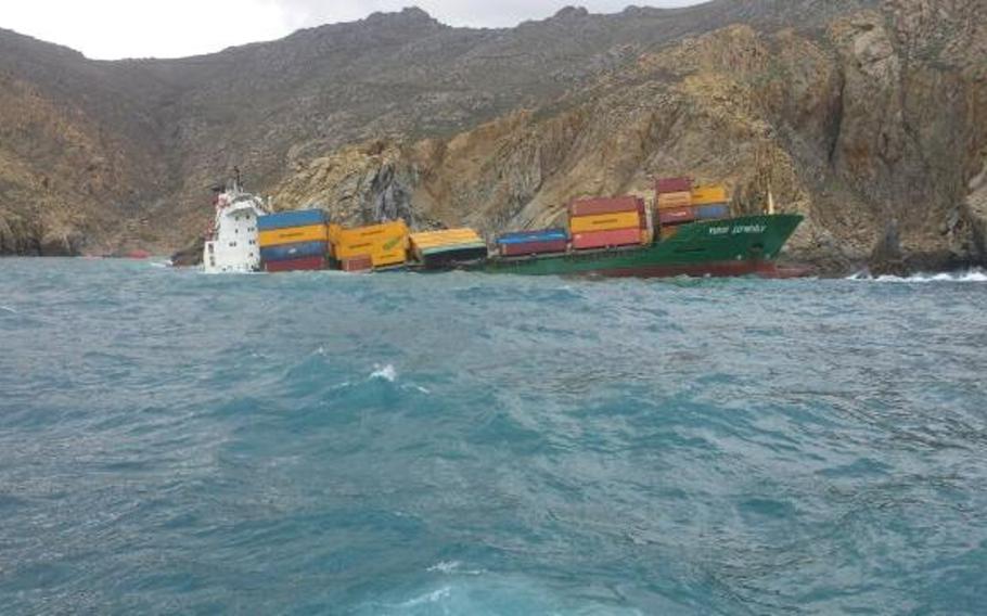 A photograph posted on the website of Greece's coast guard shows the Turkish container vessel Yusuf Cepnioglu listing by the rocky shore of Mykonos in the Aegean Sea. A Navy search-and-rescue team pulled two of the ship's mariners to safety on March 8, 2014.