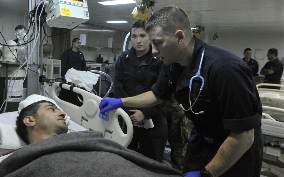 Sailors in the medical department of the USS Bataan assess a Turkish mariner recovered by a Navy search-and0rescue team from a wrecked ship off the coast of Mykonos in the Aegean Sea.
