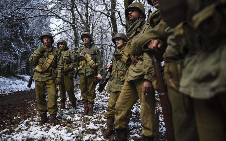 The young men of American Patrol, a Dutch re-enactment group, listen to orders from their platoon leader on Dec. 14, 2014, in the forest of Proemerberg, the large hill between St. Vith and Schönberg, Belgium where the unit they're playing, the 106th Infantry Division, actually fought during the Battle of the Bulge nearly 70 years ago.