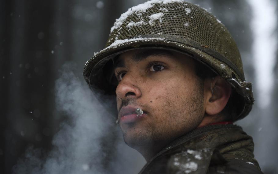 Mike Struik smokes a cigarette while portraying a soldier of the 106th Infantry Division during a re-enactment on Dec. 13, 2014. The 106th fought in the same forest 70 years ago during the Battle of the Bulge.