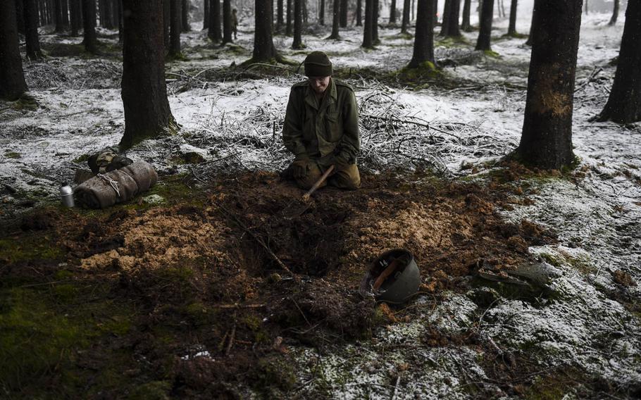 Edwin Cotter digs a foxhole on Dec. 13, 2014,  in the same forest that the 106th Infantry Division, the unit that Cotter's re-enactment group is portraying, fought in 70 years ago in the Battle of the Bulge.