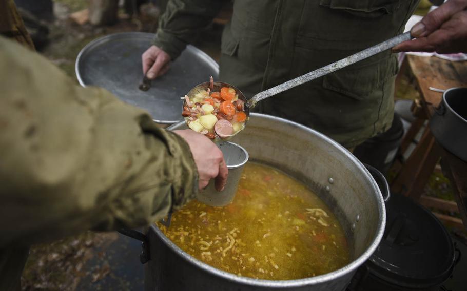 Dutch re-enactors portraying the 106th Infantry Division eat lunch that was made in a completely authentic U.S. Army field kitchen on Dec. 14, 2014. The Battle of the Bulge re-enactment took place in the heights above St. Vith, Belgium, where the 106th actually fought.