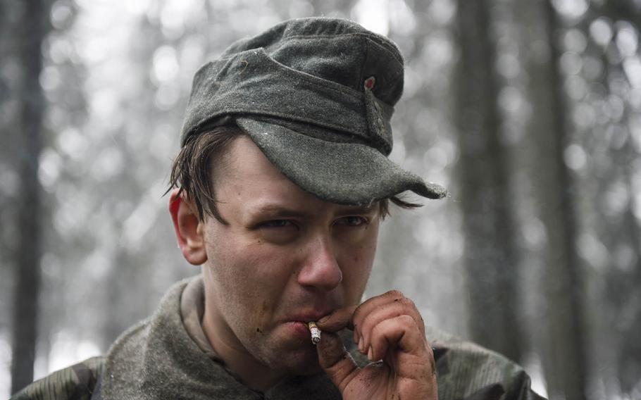 A re-enactor portraying a German soldier takes a smoke during a Battle of the Bulge re-enactment on Dec. 13, 2014. The re-enactment took place above the town of St. Vith, Belgium, where the U.S. 106th Infantry Division fought in World War II.