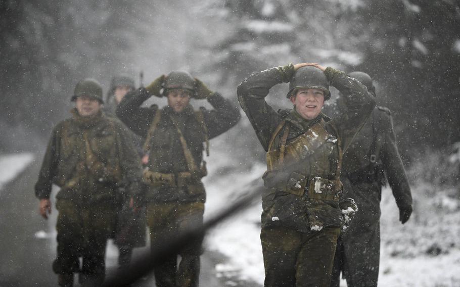 Dutch re-enactors portraying 106th Infantry Division soldiers are captured by Germans during a Battle of the Bulge re-enactment on Dec. 13, 2014, above the town of St. Vith, Belgium.
