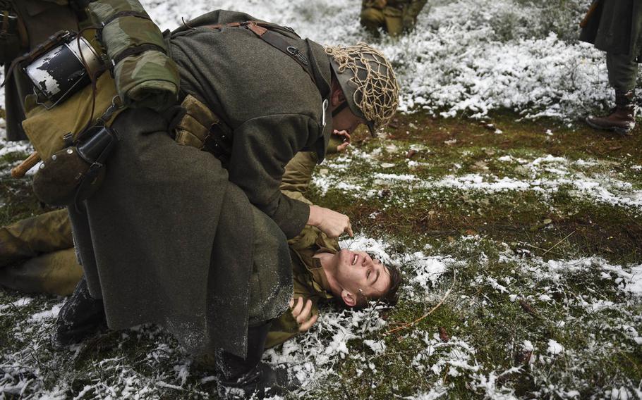 Leonard van Oord,  portraying a squad leader in the U.S. 106th Infantry Division, is taken captive by a man playing the role of a German soldier during a Battle of the Bulge re-enactment on Dec. 14, 2014.