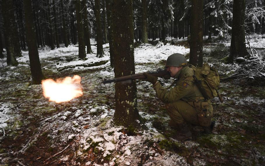 Sam Williams fires blanks from his M1 Garand semi-automatic rifle as he portrays a U.S. soldier with the 106th Infantry Division during a Battle of the Bulge re-enactment in the hills above St. Vith, Belgium, on Dec. 15, 2014.
