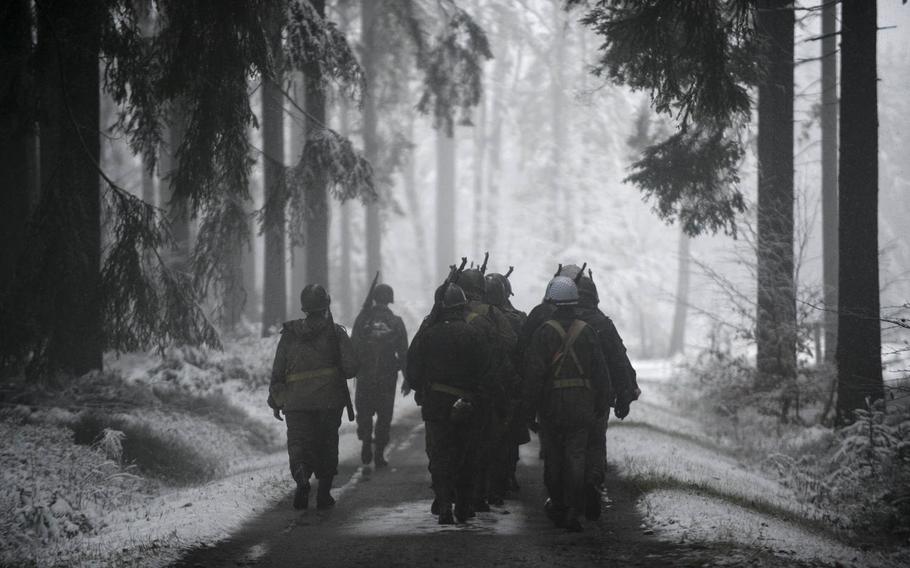 24-Dutch re-enactors portraying U.S. soldiers in the 106th Infantry Division march to the front lines above St. Vith, Belgium, during a Battle of the Bulge re-enactment Saturday, Dec. 13, 2014.