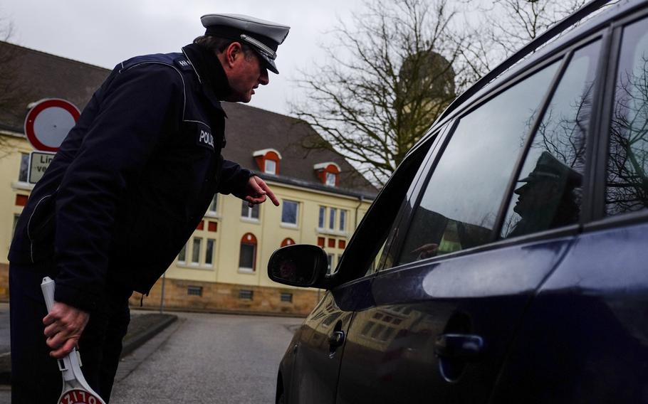 German police officer David Giesler instructs a motorist to pull into a parking lot for inspection during a random traffic checkt on the east side of Kaiserslautern, Germany, on Jan. 28, 2014.