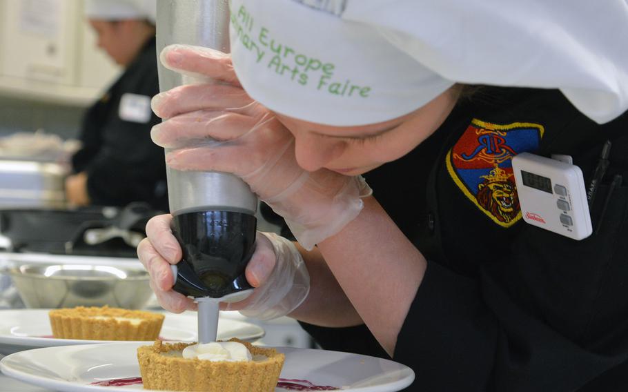Ramstein's Jessica Richardson adds whipped cream to her team's lime custard dessert at the 2015 DODDS-Europe Culinary Faire held at Kaiserslautern High School on Feb. 25, 2015.