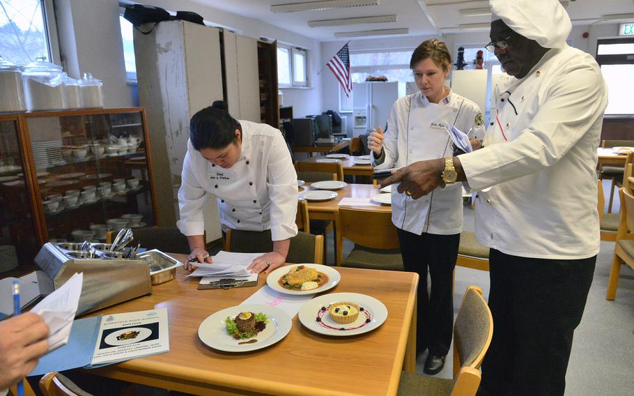 Judges Jan Parker, Julie Rylander and D.L. West, from left, discuss Ramstein High School's entries at the 2015 DODDS-Europe Culinary Faire held at Kaiserslautern High School on Feb. 25, 2015.