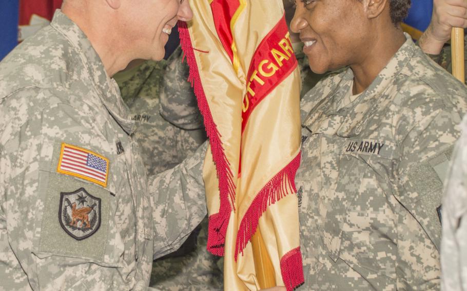 Col. Glenn K.  Dickenson, commander of U.S. Army Garrison Stuttgart, returns the unit's colors to Command Sgt. Maj. Lynice D. Thorpe during the garrison's change-of-command ceremony on Friday, Feb. 27, 2015, at Patch Barracks, Stuttgart, Germany.