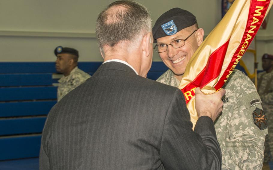 Col. Glenn K. Dickenson, incoming commander of U.S. Army Garrison Stuttgart, receives the colors from Michael D. Formica, Installation Management Command-Europe Region director, during the garrison's change-of-command ceremony on Friday, Feb. 27, 2015, at Patch Barracks, Stuttgart, Germany.