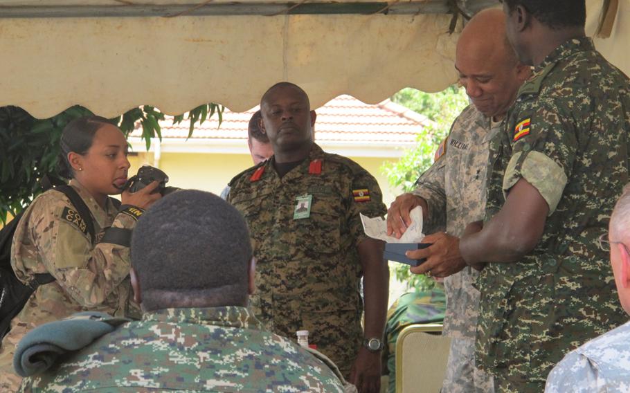 U.S. Army Africa commander Maj. Gen. Darryl Williams exchanges gifts with a Ugandan general during the annual Eastern Accord exercise in Jinja, Uganda. Ugandan Brig. Gen. Matthew Gureme, center, is the exercise's director.