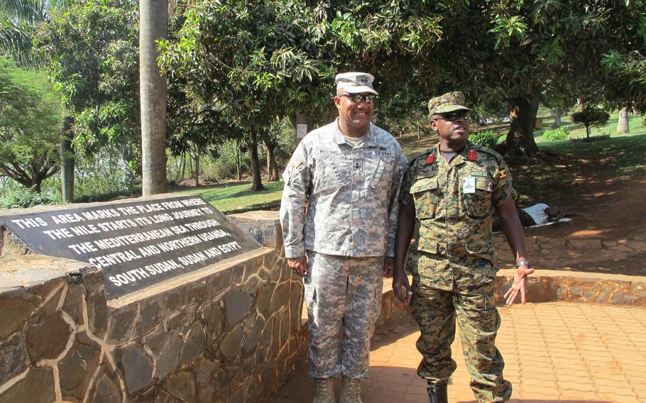 U.S. Army Africa commander Maj. Gen. Darryl Williams and  Ugandan Brig. Gen. Matthew Gureme pose at a plaque at a local tourist attraction: the source of the Nile River.